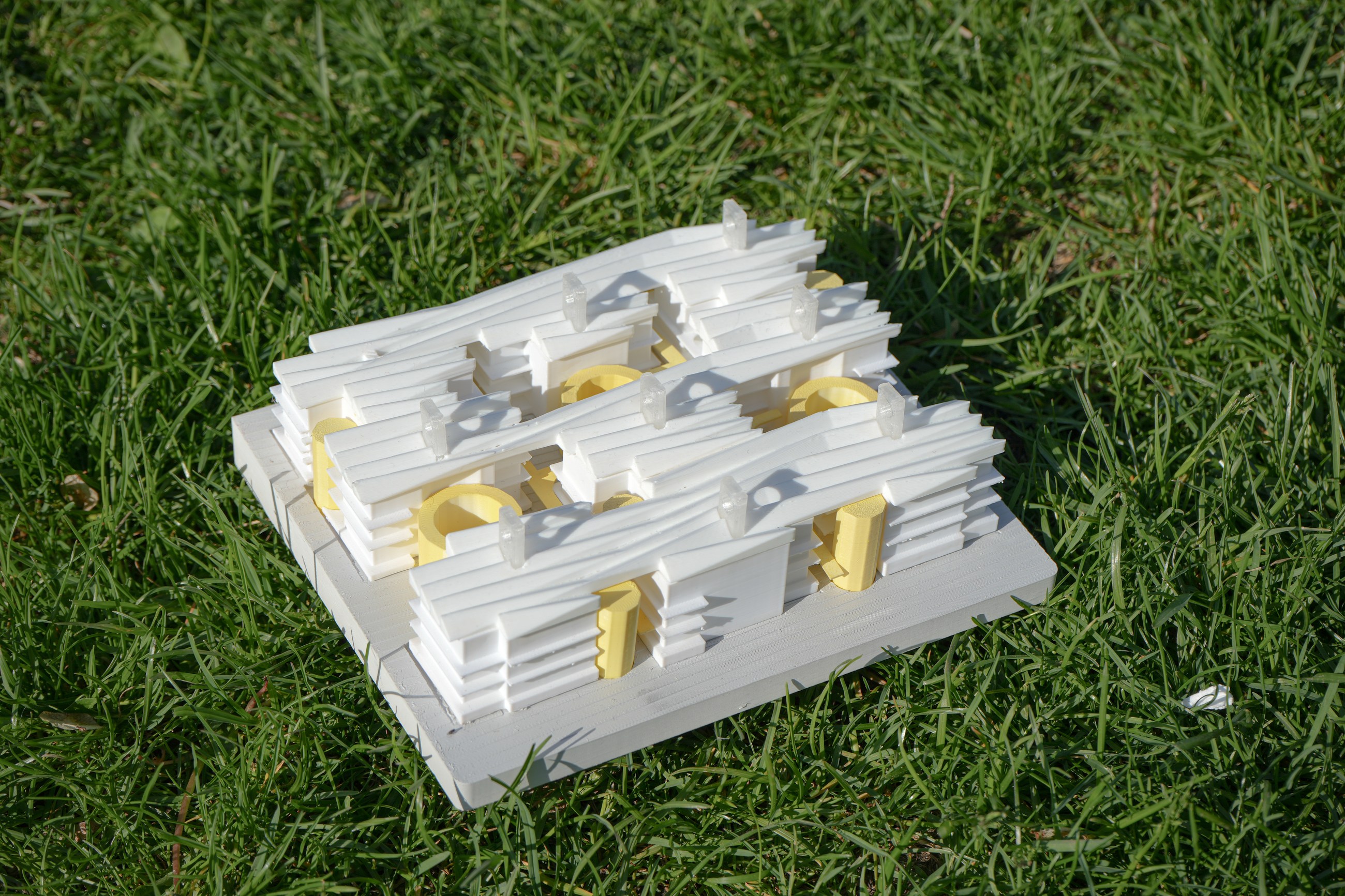 Small white model testing a compact housing cluster around shared cores