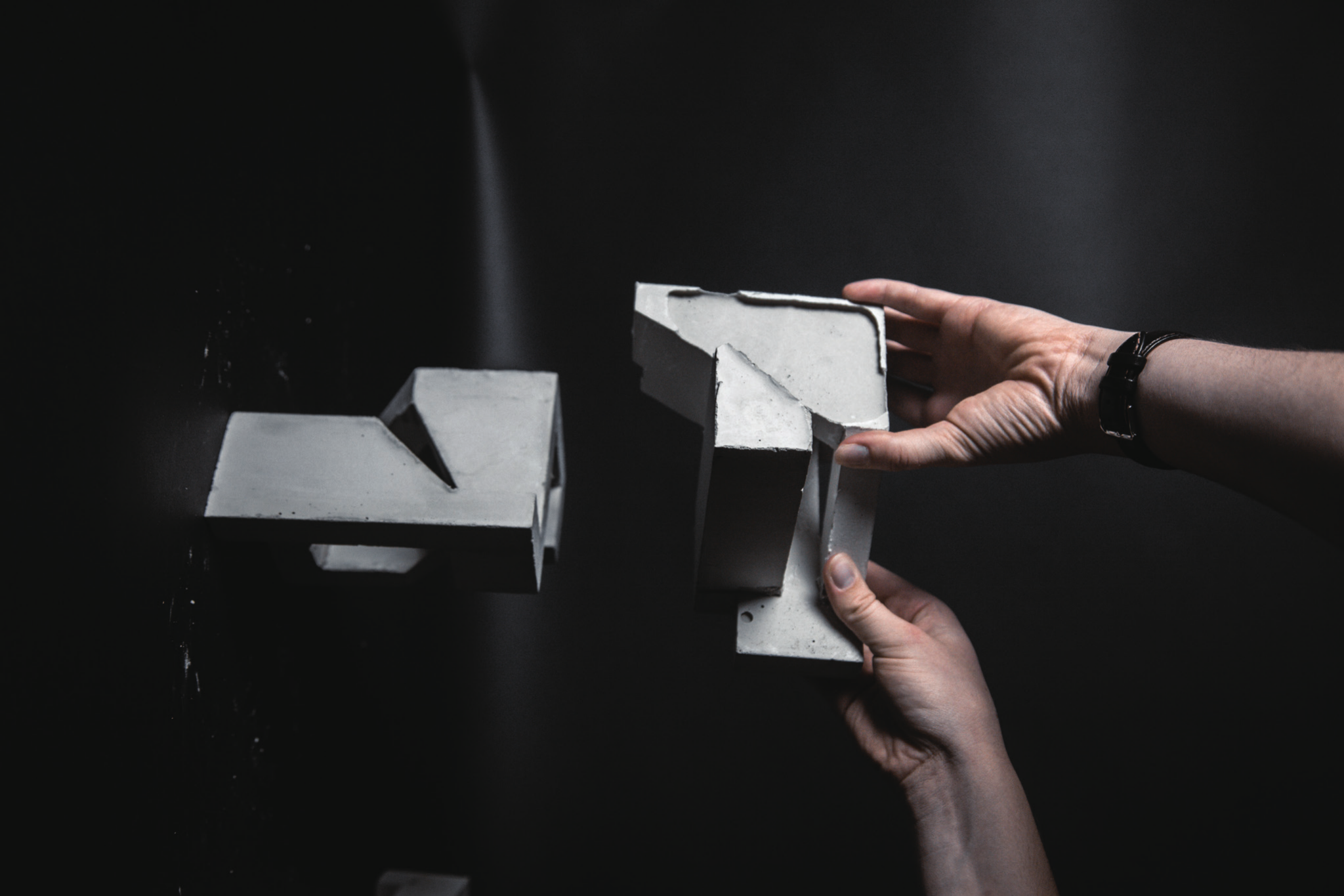Two concrete studies being joined by hand